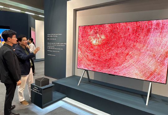 LG전자가 '프리즈 서울 2023'에서 한국 추상미술의 거장 고 김환기 작가의 원화와 그의 작품을 초대형 올레드 TV로 새롭게 표현한 미디어아트를 선보인다고 7일 밝혔다. 박형세(오른쪽) LG전자 HE사업본부장이 무선 올레드 TV 'LG 시그니처 올레드 M'으로 미디어아트를 감상하고 있다. LG전자 제공